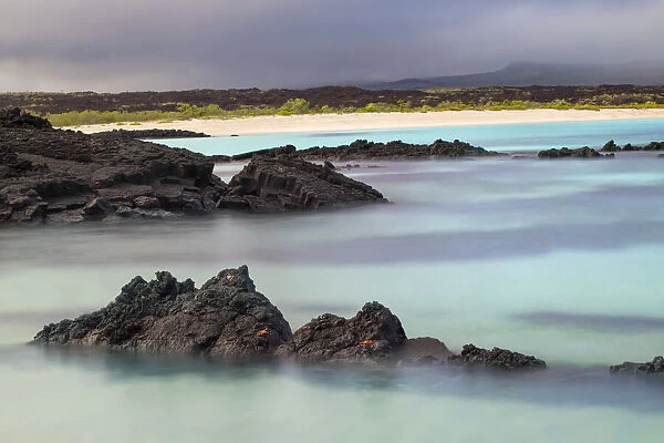 Lava rocks along tranquil shoreline of San Cristobal Island, Galapagos, Ecuador