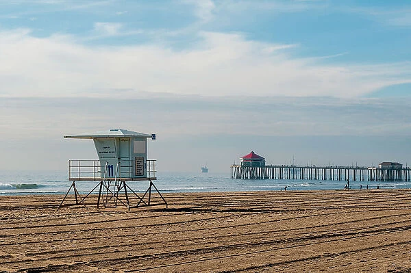 Lifeguard shack and pier on almost deserted Huntington Beach, on the Pacific Ocean, California