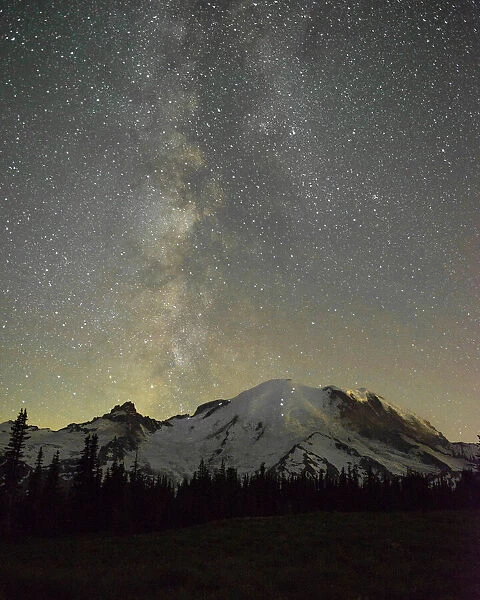 The lights of climbers can be seen on the mountain as the Milky Way rises behind Mt