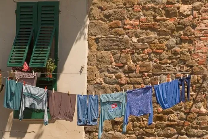 Framed Print : A line of clothes dries between buildings near an open air market in Figline, Tusacny, Italy Framed Print : A line of clothes dries between buildings near an open air market in Figline, Tusacny, Italy