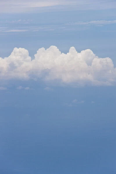 A lone Cumulus cloud high above the Pacific Ocean