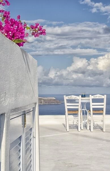 Two lonely romantic chairs on balcony with sky in Fira in Santorini Greece in Greek