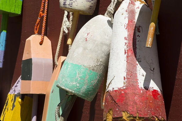 Maine, Bar Harbor. Colorful lobster trap buoys hanging on wall