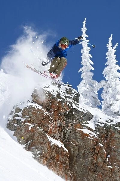 Man jumping colorful cliff and skiing in fresh powder at Whitefish Mountain Resort in Montana