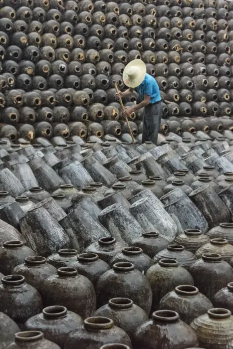 Framed Print : Man in the middle of big pile of wine jars stacked up at a local rice winery, Wuxi Framed Print : Man in the middle of big pile of wine jars stacked up at a local rice winery, Wuxi