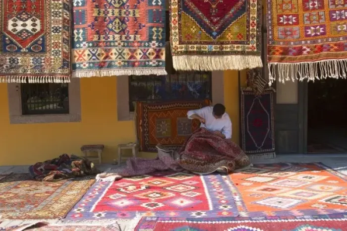Framed Print : Man sewing the sides of a kilim in front of a local carpets shop, Pergamon (Pergamum Framed Print : Man sewing the sides of a kilim in front of a local carpets shop, Pergamon (Pergamum
