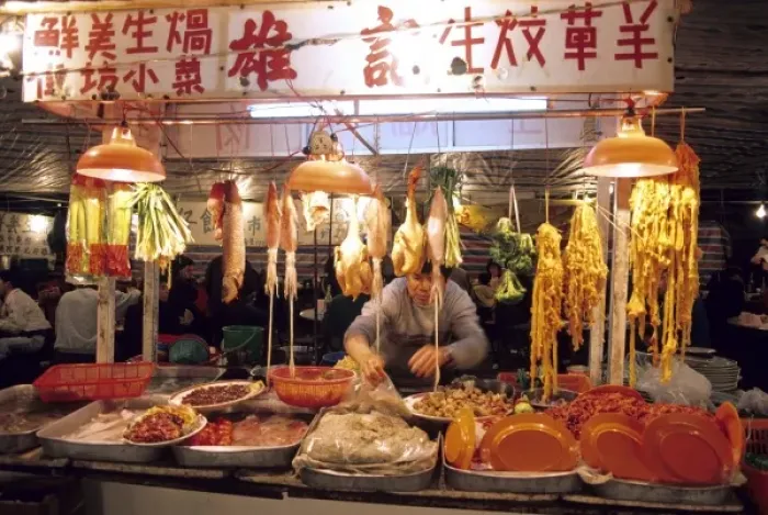 Framed Print : A man works at a night market selling meat and fish in Hong Kong Framed Print : A man works at a night market selling meat and fish in Hong Kong