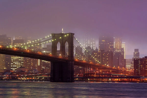 Manhattan skyline and the Brooklyn bridge in the mist at dusk