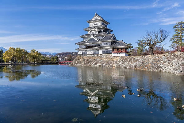 The Matsumoto Castle with reflection in the moat with bridge