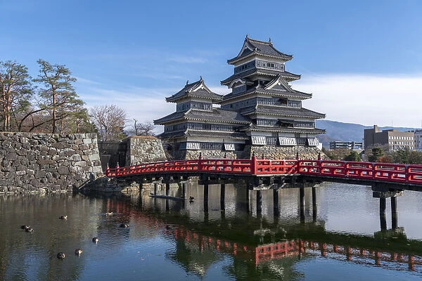 The Matsumoto Castle as seen from the bridge with the city buildings in the background