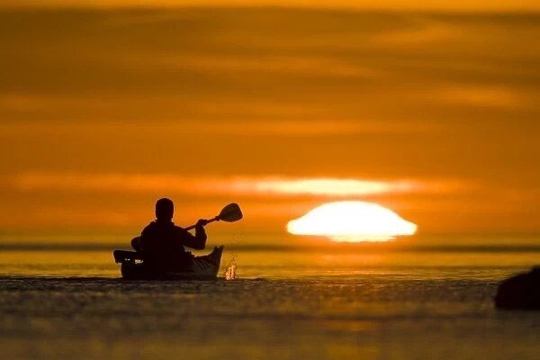 Mexico, Baja, Sea of Cortez. Sea kayaker paddles toward sunrise. (MR)