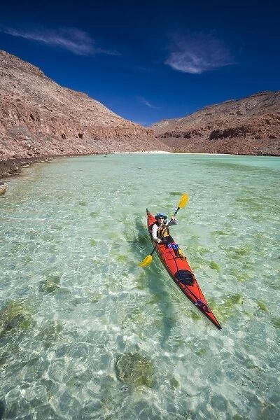 Mexico, Baja, Sea of Cortez. Sea kayaker paddles a bay on Espiritu Santo. (MR)