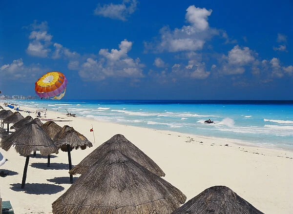 06. Mexico, Cancun, Sunshades along beach with parachute in background