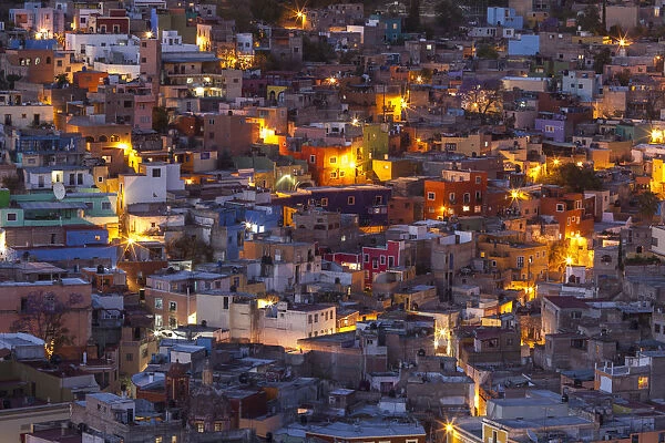 Mexico, Guanajuato. Street lights add ambience to this twilight village scene