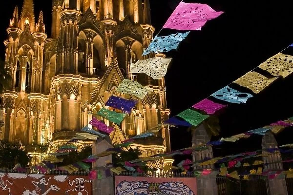 Mexico, San Miguel de Allende. Festival banners fly at night in front of illuminated