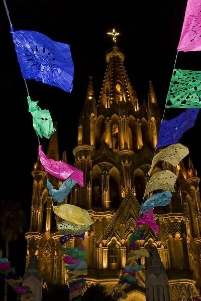 Mexico, San Miguel de Allende. Festival banners fly at night in front of illuminated