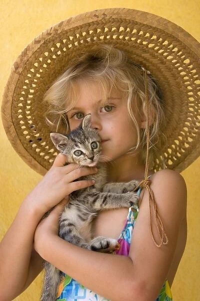Mexico. Young girl embraces her kitten. (MR)