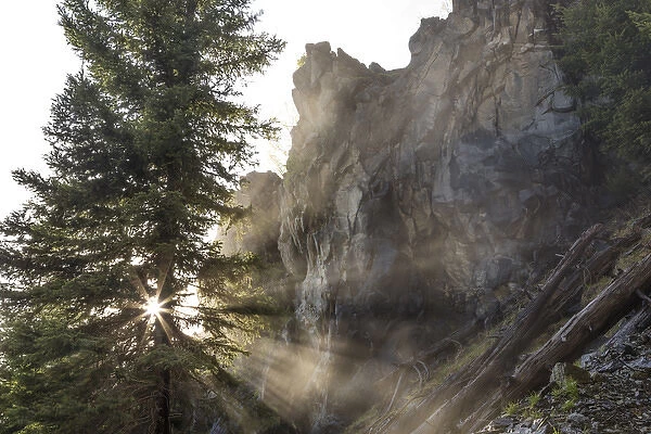 Mist from Holland Falls is backlit by setting sun in the Lolo National Forest, Montana