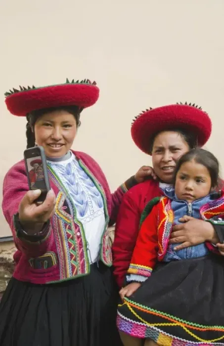 Framed Print : Modern life in Peru family in traditional dress and hat taking photo with cell phone communicating