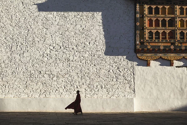 Monk walks through the courtyard of Rinpung Dzong (Monastery) also called Paro Dzong