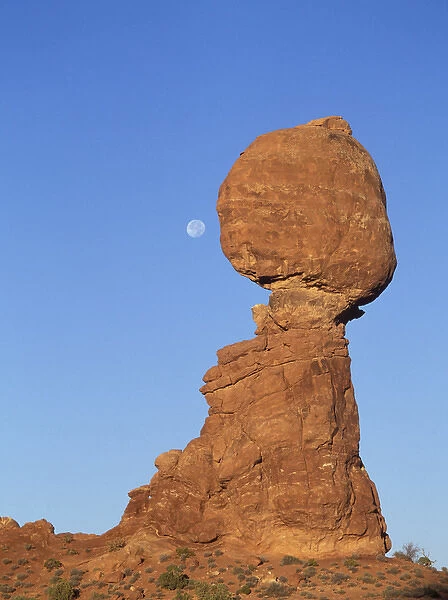 Full moon descending above Balancing Rock in Arches National Park, Utah