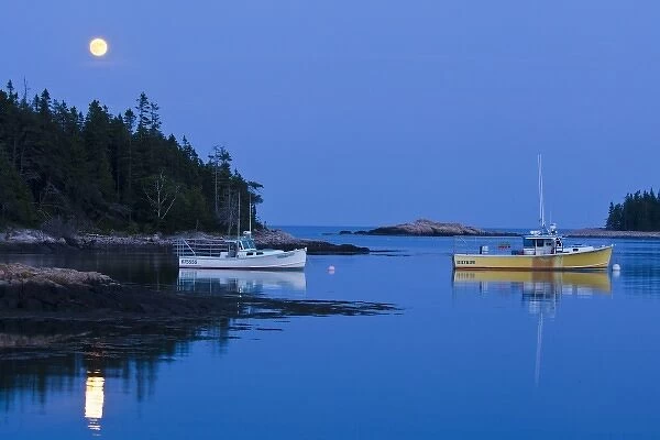 Full moon illuminates lobster boats in Bunker Harbor, Maine, USA