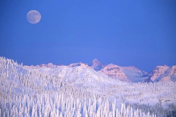 Full moon rising above Glacier National Park Peaks from summit of Big Mountain in