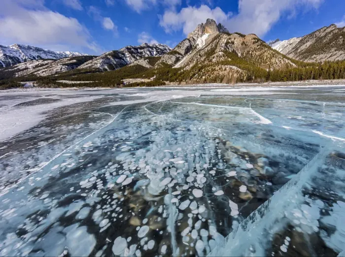 Framed Print : Mt. Abraham at sunrise and methane ice bubbles under clear ice on Abraham Lake near Nordegg