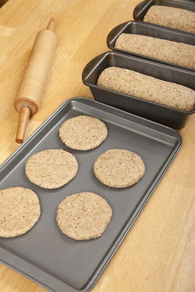 Multigrain bread dough formed into loaves and circles (to make hamburger buns) ready