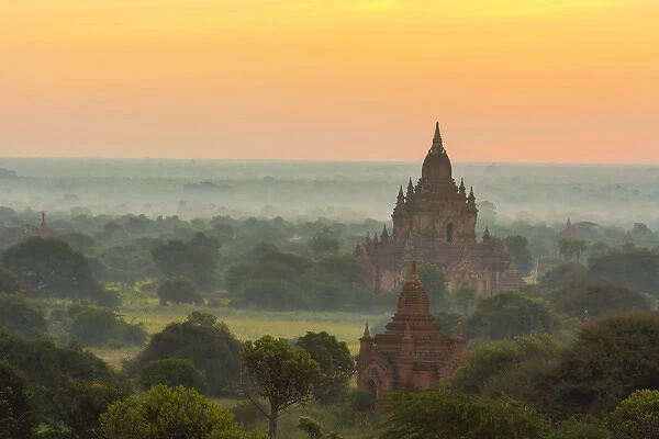 Myanmar. Bagan. Smoke from cooking fires shrouds the temples of Bagan at sunrise