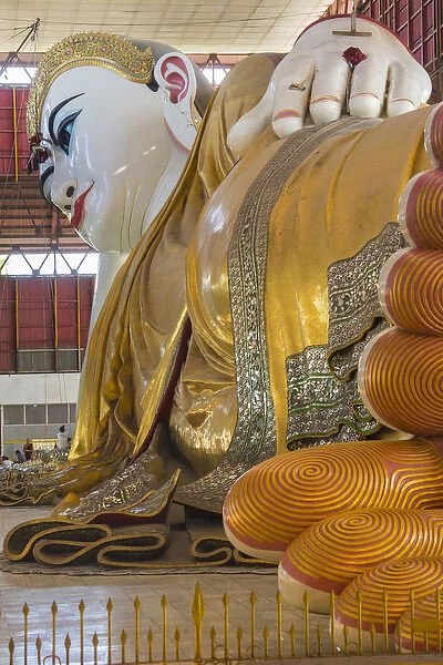 Myanmar. Yangon. Chauk Htat Gyi Pagoda. Monk cleaning a giant reclining Buddha