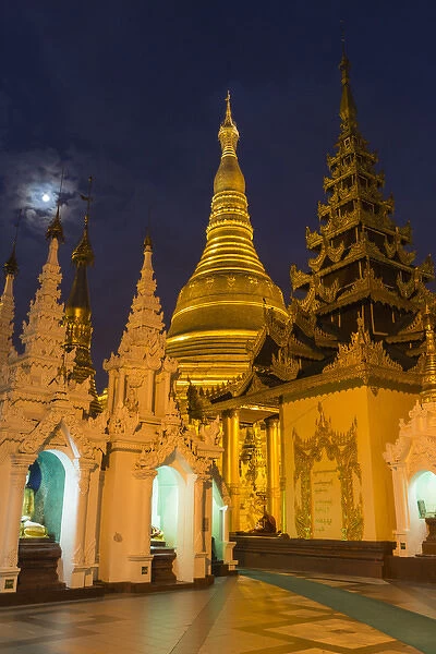 Myanmar, Yangon. Golden stupa and temples of Shwedagon Pagoda at night with moon