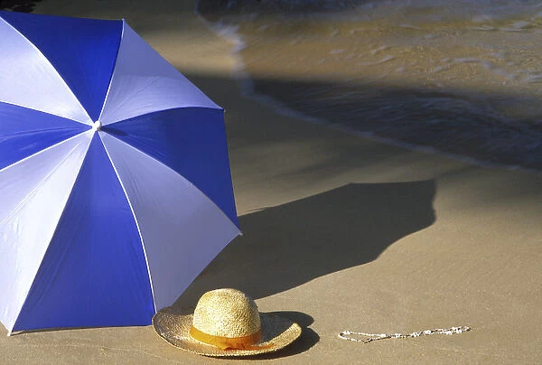 N. A. USA, Maui, Hawaii. Umbrella and hat on beach cove
