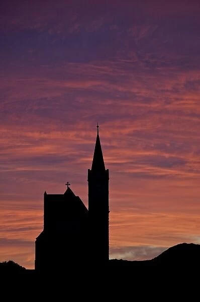 Namibia, Luderitz. A church is silhouetted against the sunrise