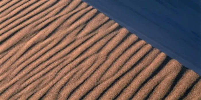 Framed Print : Namibia, Namib Desert, Setting sun lights wind-blown sand along dunes near coastal