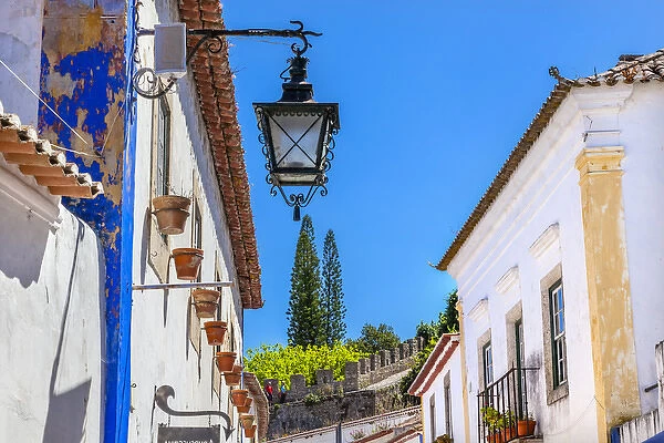 Narrow White Street 11th Century Castle Wall Medieval Town Lamp Obidos Portugal. Castle