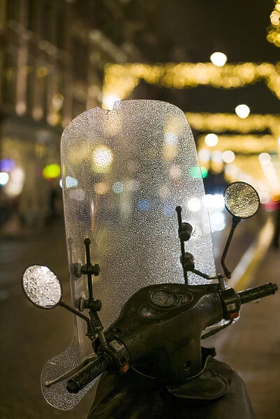 Netherlands, Amsterdam, Utrechtstraat street, motorbike and Holiday decorations, evening