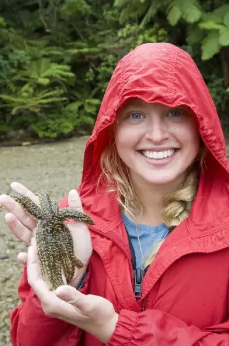 Framed Print : New Zealand, South Island, Marlborough Sounds. Joanna Jensen examining a starfish. (MR)