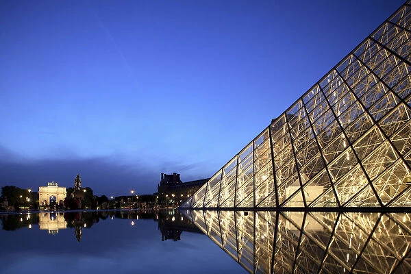 The night view of the glass Pyramid of Musee du Louvre with Arc de Triomphe du Carrousel