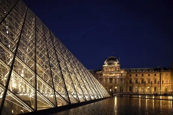 The night view of the glass Pyramid with the Sully Wing of Musee du Louvre in the background