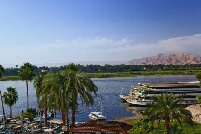Framed Print : Nile River and docked sightseeing boats, and distant Valley of the Kings, from modern Framed Print : Nile River and docked sightseeing boats, and distant Valley of the Kings, from modern