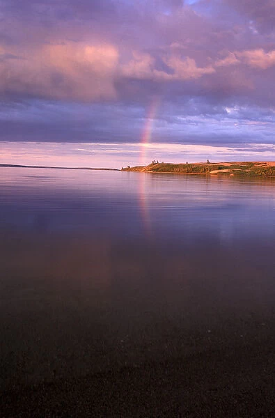 North America, Canada, Northwest Territories. Lake reflection and rainbow