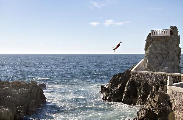North America, Mexico, Mazatlan. Cliff diver (clavadista) diving from El Mirador at Paseo Claussen