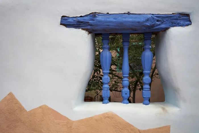 Framed Print : North America, United States, New Mexico, Albuquerque. Blue wooden lintel and carved spindles support a decorative window opening in a stucco wall
