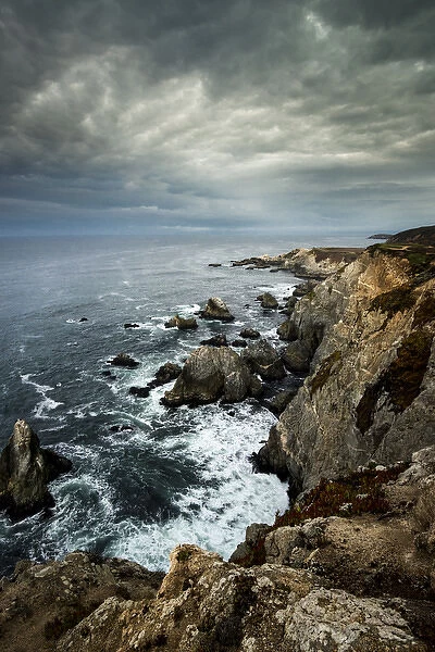 North America, USA, California. Clouds approaching the cliffs and surging waves at Bodega Head