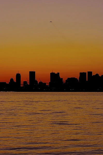 North America, USA, Massachusetts. A sunset view of Boston from the shore in Winthrop