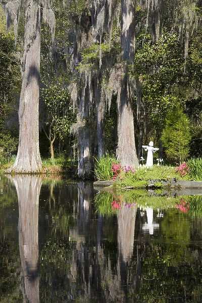 North America, USA, South Carolina, Charleston. Garden Statue and Blooming Azaleas