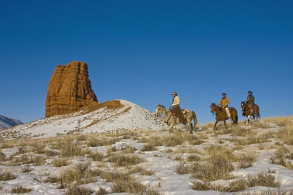 North America; USA; Wyoming; Shell; Cowboys on Ridge riding Horse through the Snow