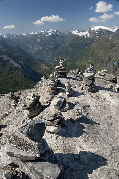 Norway, Geiranger. Travelers stone stacks with a view of the port of Geiranger from Mt