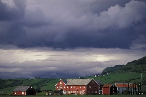 Norway, Orkanger, Trondheim area. Red farm buildings and storm coulds